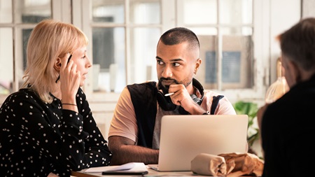 Dame og mand sidder foran en PC skærm